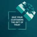 A teal and white Christmas gift box against a teal background. Inside the box is a message: “Give your customers the gift of trust.”