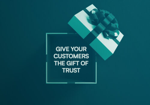 A teal and white Christmas gift box against a teal background. Inside the box is a message: “Give your customers the gift of trust.”