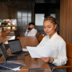 A lady reviewing documents in an office setting.