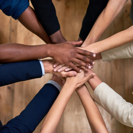 Several hands stacked together to symbolize trust, unity, and strong workplace relationships.